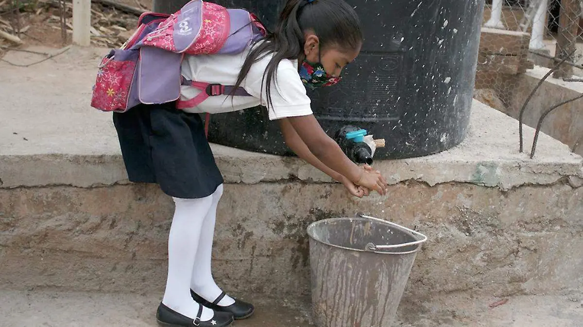 Niña lavándose las manos en la escuela